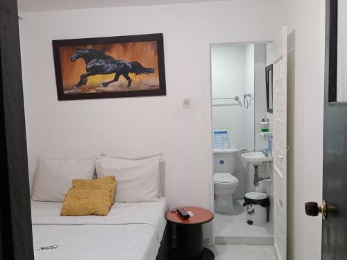 1 dormitorio con 1 cama con una foto de un caballo en la pared en Hotel Casa Nini en Bogotá
