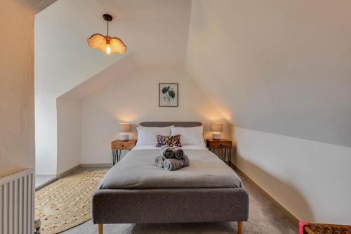 a bedroom with a bed with a teddy bear on it at Cheerful 3 bed Grade II Central Cottage in Cirencester