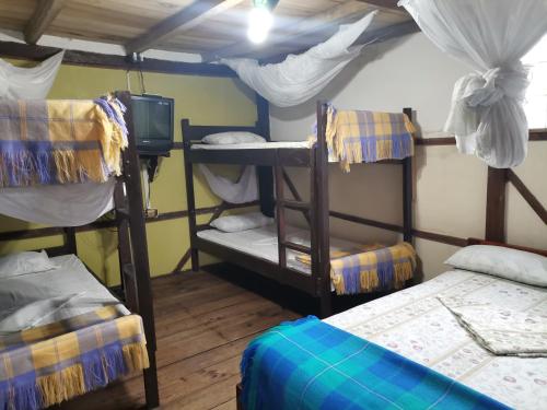 a room with three bunk beds and a tv at CABAÑAS ECOLOGICAS STEPHANIE JIRETH in Tonsupa