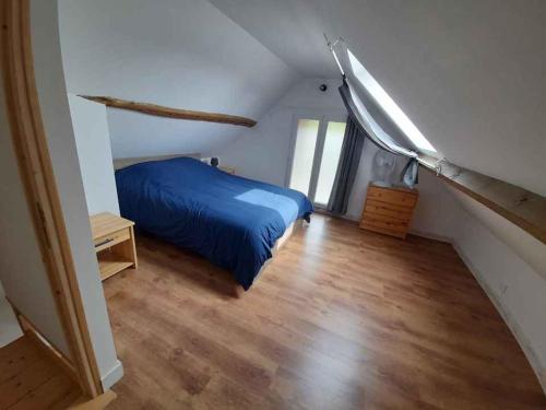 1 dormitorio con 1 cama azul en el ático en Maison au calme, en Chelles