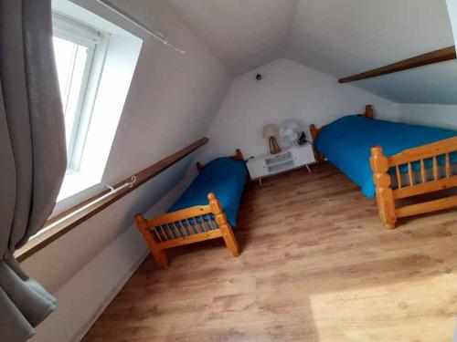 1 dormitorio con 2 camas y ventana en Maison au calme, en Chelles