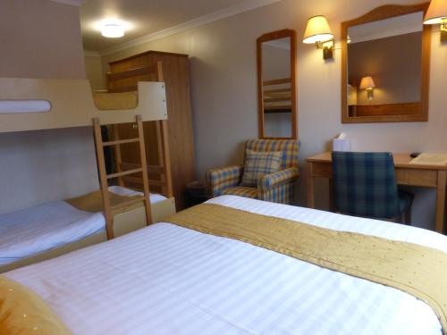 a bedroom with a bed and a bunk bed at Norseman Hotel in Wick