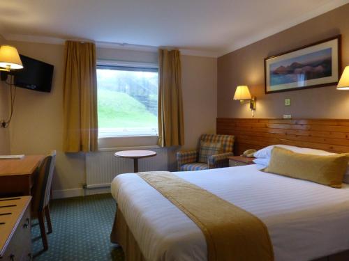 a hotel room with a large bed and a window at Norseman Hotel in Wick