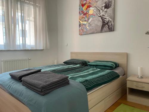a bedroom with a bed with green blankets on it at Apartment Jelena in Zagreb