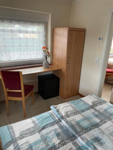 1 dormitorio con cama, escritorio y ventana en Ferienwohnung Arthur, en Luckenwalde