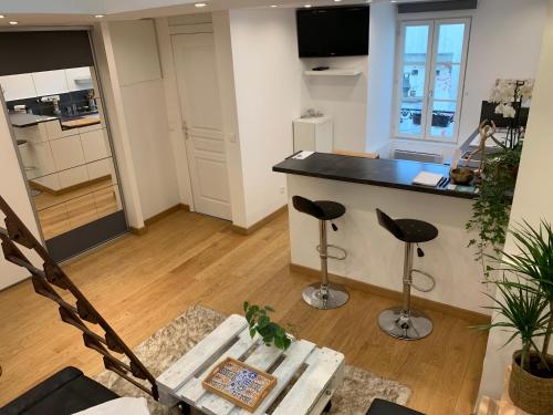 une cuisine avec un comptoir et des tabourets dans une pièce dans l'établissement Lovely studio at Île Saint-Louis, à Paris