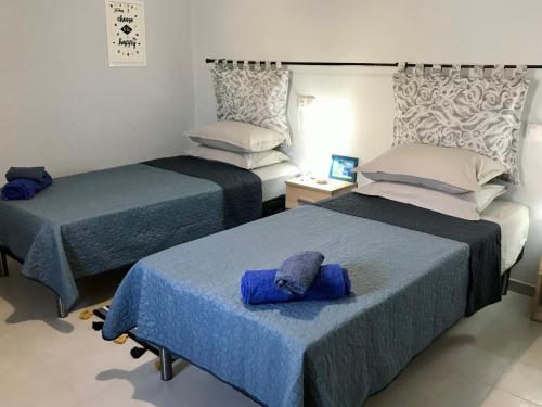 - une chambre avec 2 lits et des serviettes bleues dans l'établissement The Mill House Stella, à Symi