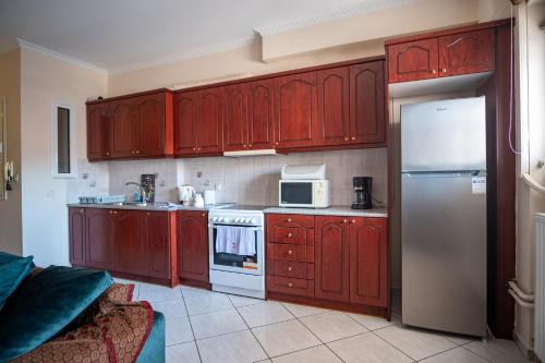 a kitchen with red wooden cabinets and a refrigerator at Erifili Luxury Apartment in Samos
