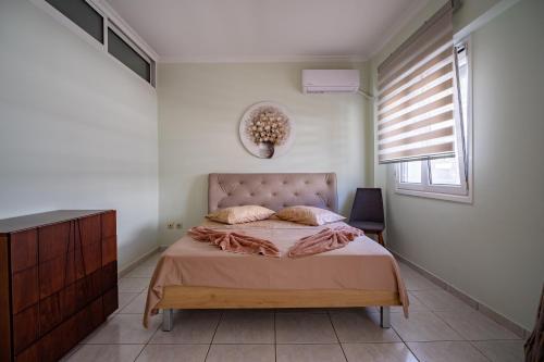 a bedroom with a bed in a room with a window at Erifili Luxury Apartment in Samos