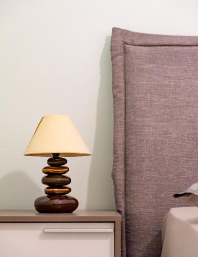 a lamp on a night stand next to a bed at Erifili Luxury Apartment in Samos