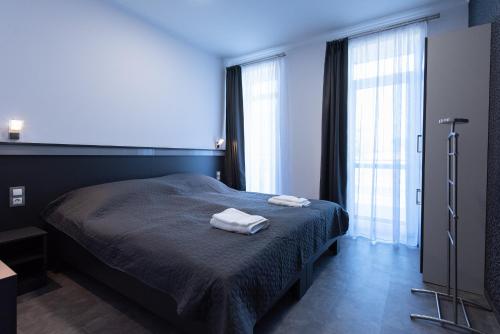 a bedroom with a bed with two towels on it at Theresa Vendégház in Kiskunmajsa