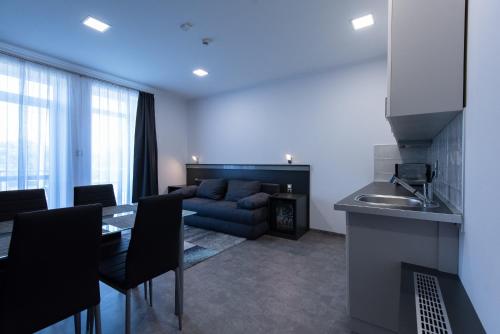 a kitchen and living room with a table and a couch at Theresa Vendégház in Kiskunmajsa