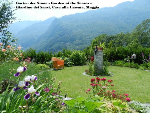 a garden with a view of the mountains at CASA ALLA CASCATA House by the Waterfall and Garden of Senses in Maggia