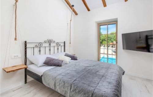 a white bedroom with a bed and a tv at Pet Friendly Home In Malinska With Outdoor Swimming Pool in Malinska