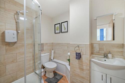 a bathroom with a toilet and a sink and a shower at 30 percent OFF! Emerald 3 Bed Gem in Southampton in Totton