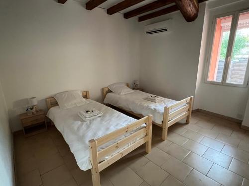 sypialnia z dwoma łóżkami i oknem w obiekcie Gîte tout confort en Cévennes 3 étoiles w mieście Saint-Martin-de-Valgalgues