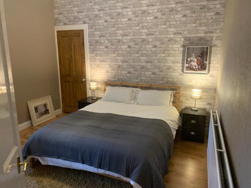 1 dormitorio con cama y pared de ladrillo en 1 bed central apartment, Hawick en Hawick