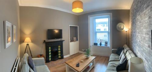 a living room with a couch and a fireplace at 1 bed central apartment, Hawick in Hawick