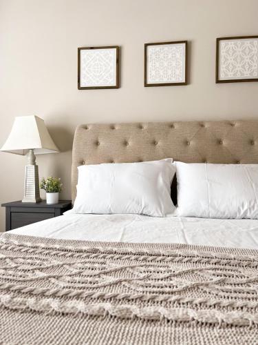 una camera da letto con un grande letto con cuscini bianchi di Lovely Townhouse! ad Auburn
