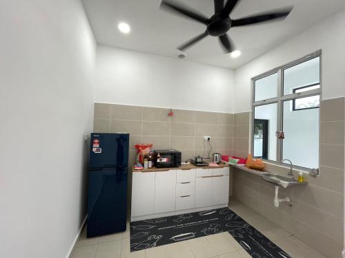 uma cozinha com um frigorífico azul e um lavatório em 福氣安康 Ray’s Homestay em Batu Pahat