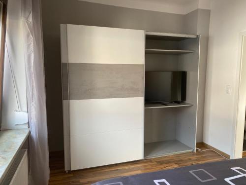 een witte kast met een tv in een kamer bij Apartment Katharina in Püttlingen