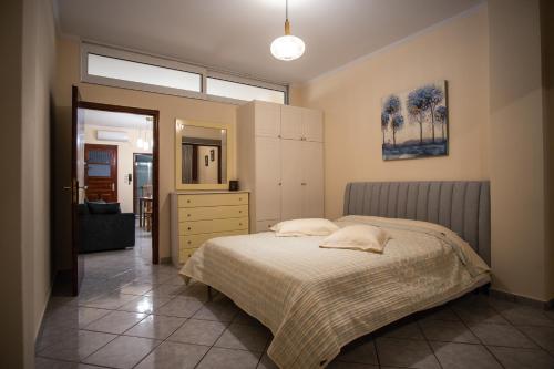 1 dormitorio con cama, tocador y espejo en Ariadni Luxury Apartment en Samos
