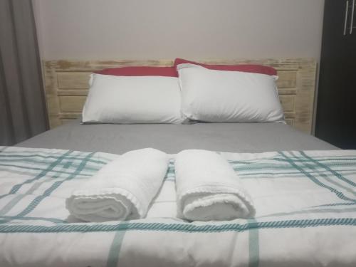 a bed with two rolled towels on it at Elegante Apartamento no centro de Curitiba in Curitiba