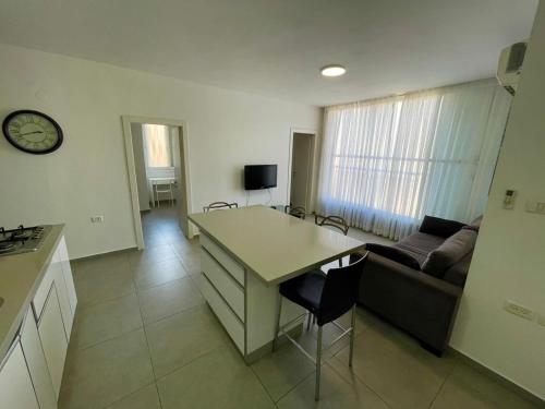 a kitchen and living room with a couch and a table at GK apartment Harmony in Bat Yam