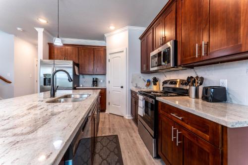 a kitchen with wooden cabinets and a counter top at Nest - a cheerful 4 bedroom, 4.5 bath new townhome in Aggieland in College Station