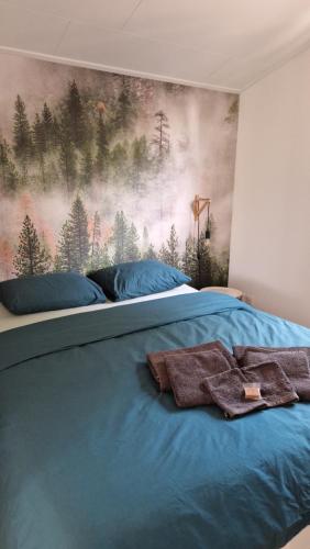 1 dormitorio con 1 cama con una pintura en la pared en Vakantiehuisje Vechtdal, en Stegeren