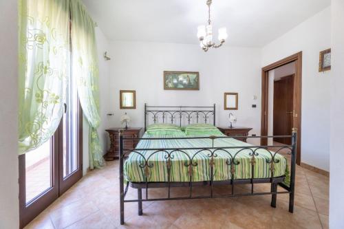 ein Schlafzimmer mit einem Bett und einem großen Fenster in der Unterkunft bello e confortevole in Torre Suda