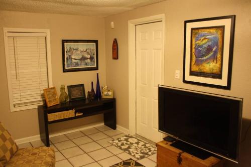 a living room with a flat screen tv and a door at Key West Style Historic Home in Coconut Grove Florida The Yellow House in Miami