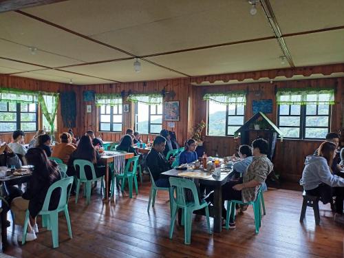 a group of people sitting at tables in a restaurant at Las vegas lodge and restaurant in Banaue