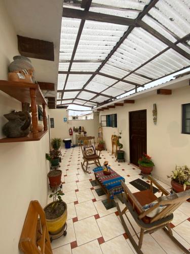 een woonkamer met stoelen en tafels en een plafond bij La Chocita Ward in Lima
