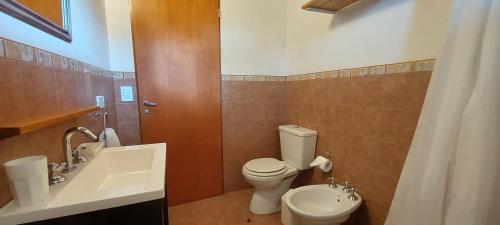a bathroom with a white toilet and a sink at Casa Condal in Villa General Belgrano