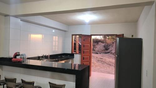 eine Küche mit einem schwarzen Kühlschrank im Zimmer in der Unterkunft Shambala centro de São Tomé das letras in São Thomé das Letras