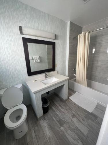 ein Badezimmer mit einem Waschbecken, einem WC und einer Badewanne in der Unterkunft Keystone Motel in Norwalk