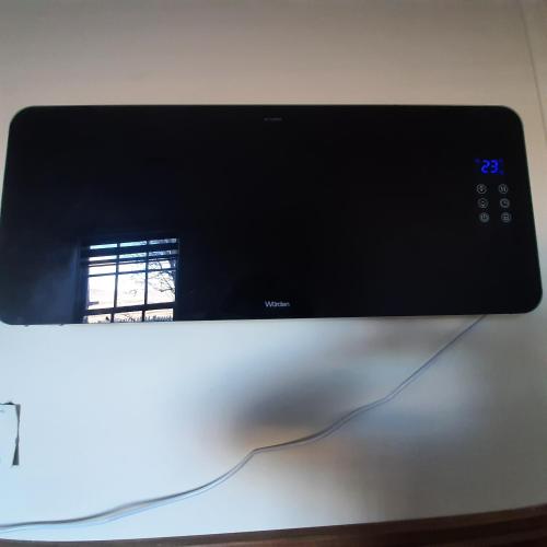 a computer monitor sitting on a table with a window at Riverline lodge in Cerro Castillo