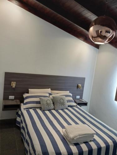 a bedroom with a bed with blue and white stripes at Cabañas del Cerro Mirador in Villa Rumipal
