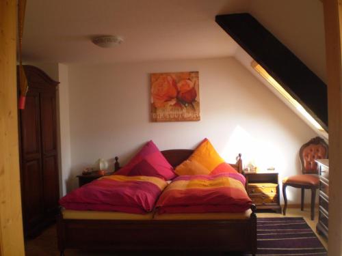 a bed with colorful pillows in a room at Grundhäusle in Gütenbach