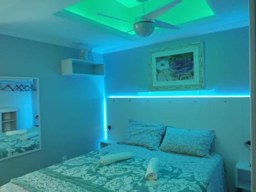 Habitación azul con cama con ventilador de techo en ** SUITE PRIVATIVA PRAIA DO FORTE CABO FRIO **, en Cabo Frío