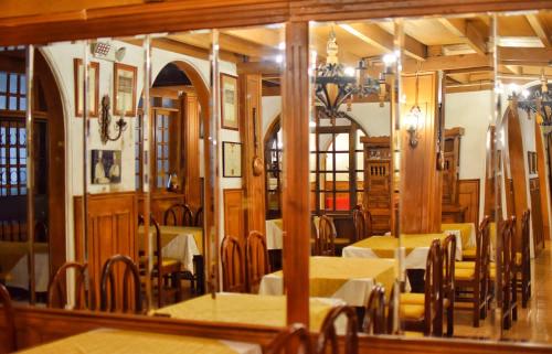 a dining room with tables and chairs and a mirror at Hotel Ambassador in Quito