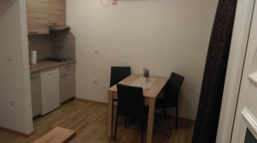 a kitchen with a table and chairs in a room at Rooms LU&LA in Velika Gorica