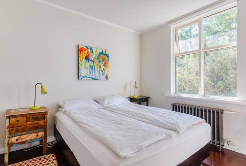 1 dormitorio blanco con 1 cama y 2 ventanas en Sem Apartments, en Reikiavik