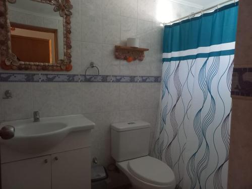 y baño con lavabo, aseo y cortina de ducha. en Bahía Loreto en Caldera