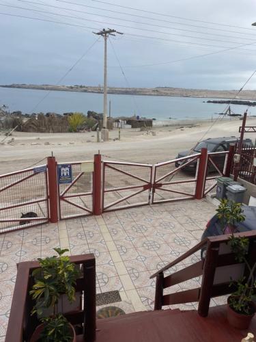 a red fence with a view of a beach at Bahía Loreto in Caldera