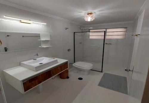 Apartamento encantador perto da Avenida Paulista في ساو باولو: حمام أبيض مع حوض ومرحاض