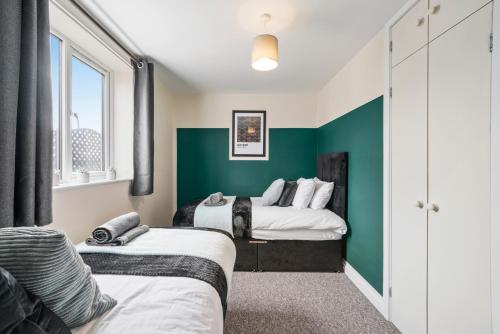 two beds in a room with green walls at 30 percent OFF! Exquisite Gems of Southampton! - 3 Bed in Totton