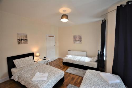 a living room with two beds and a couch at Cheerful 3 Bedroom Home in Greater London in London