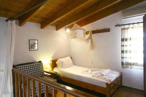 a small bedroom with a bed and a balcony at Proimos Maisonnettes in Plataniás